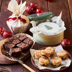 christmas hamper Brownies, mince pies, Christmas cake, gift tin, christmas pudding on a wooden table with festive decorations. !