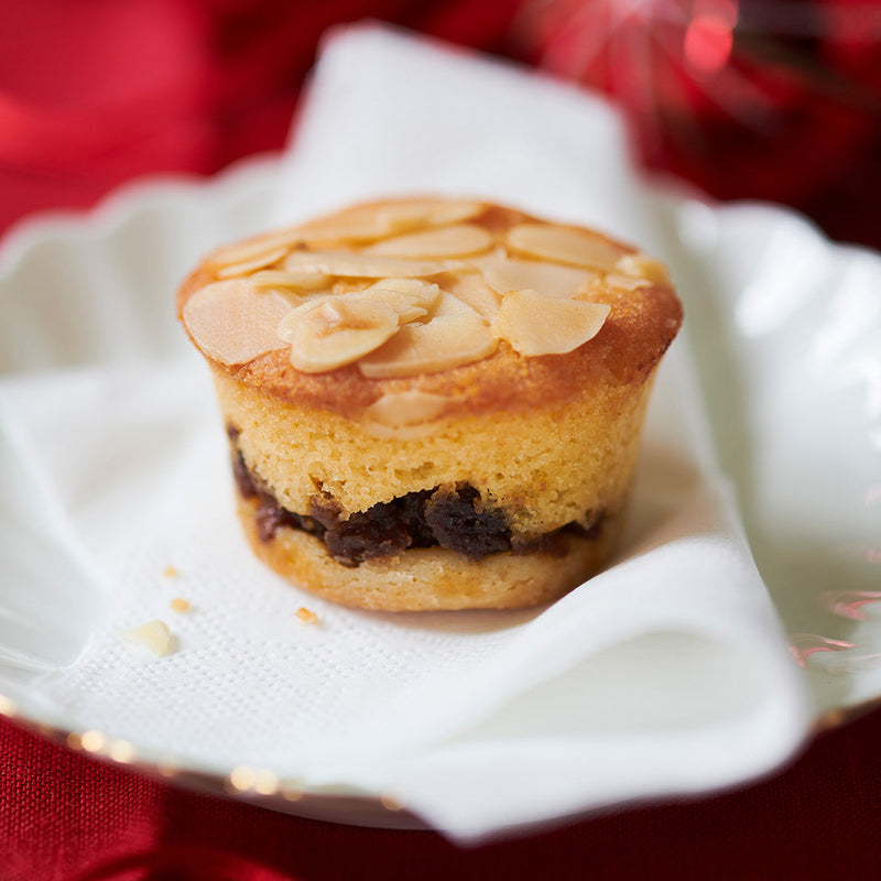 frangipane Mince pie with almonds on a white plate against a red background